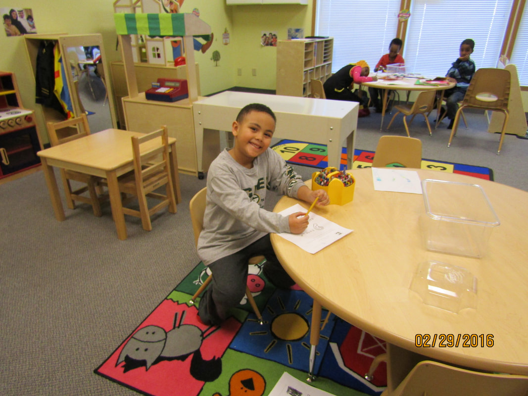 Child smiling while working on a classroom activity