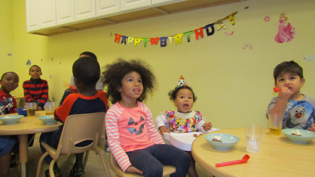Children gathered around a classroom table during a celebration
