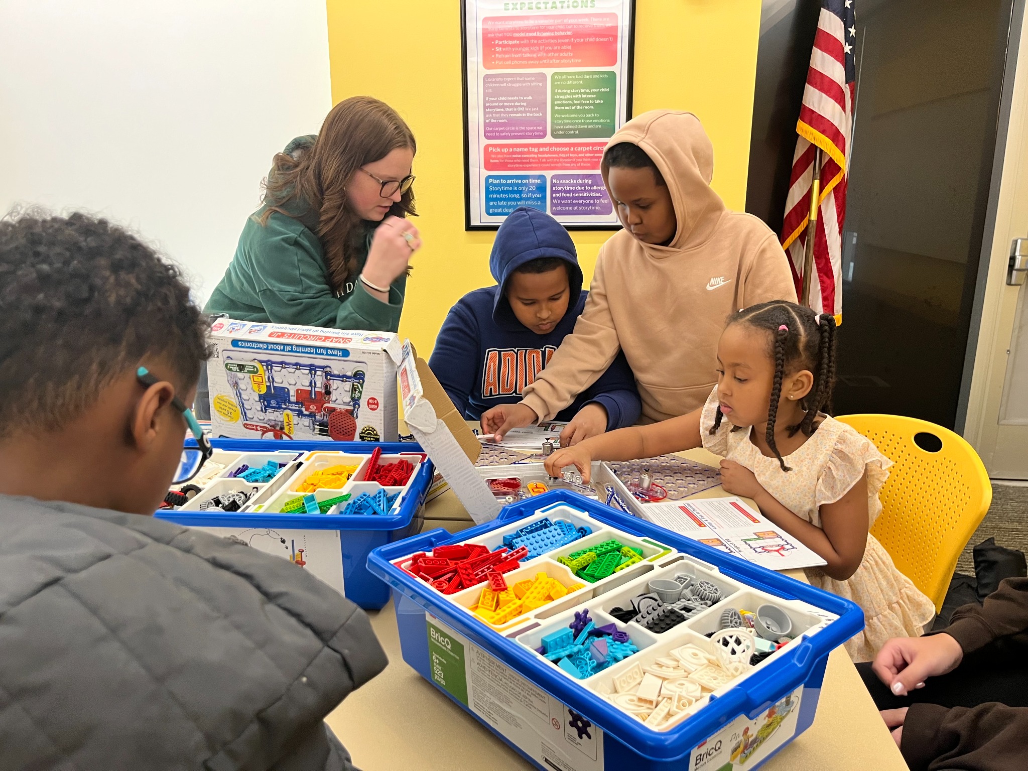 Children exploring building and electronics kits together at a table